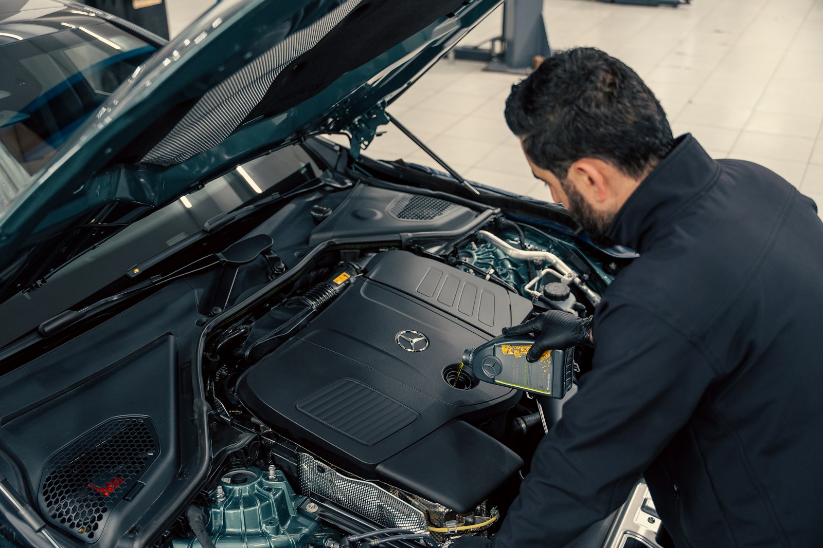 Mechaniker prüft einen Automotor bei geöffneter Motorhaube
