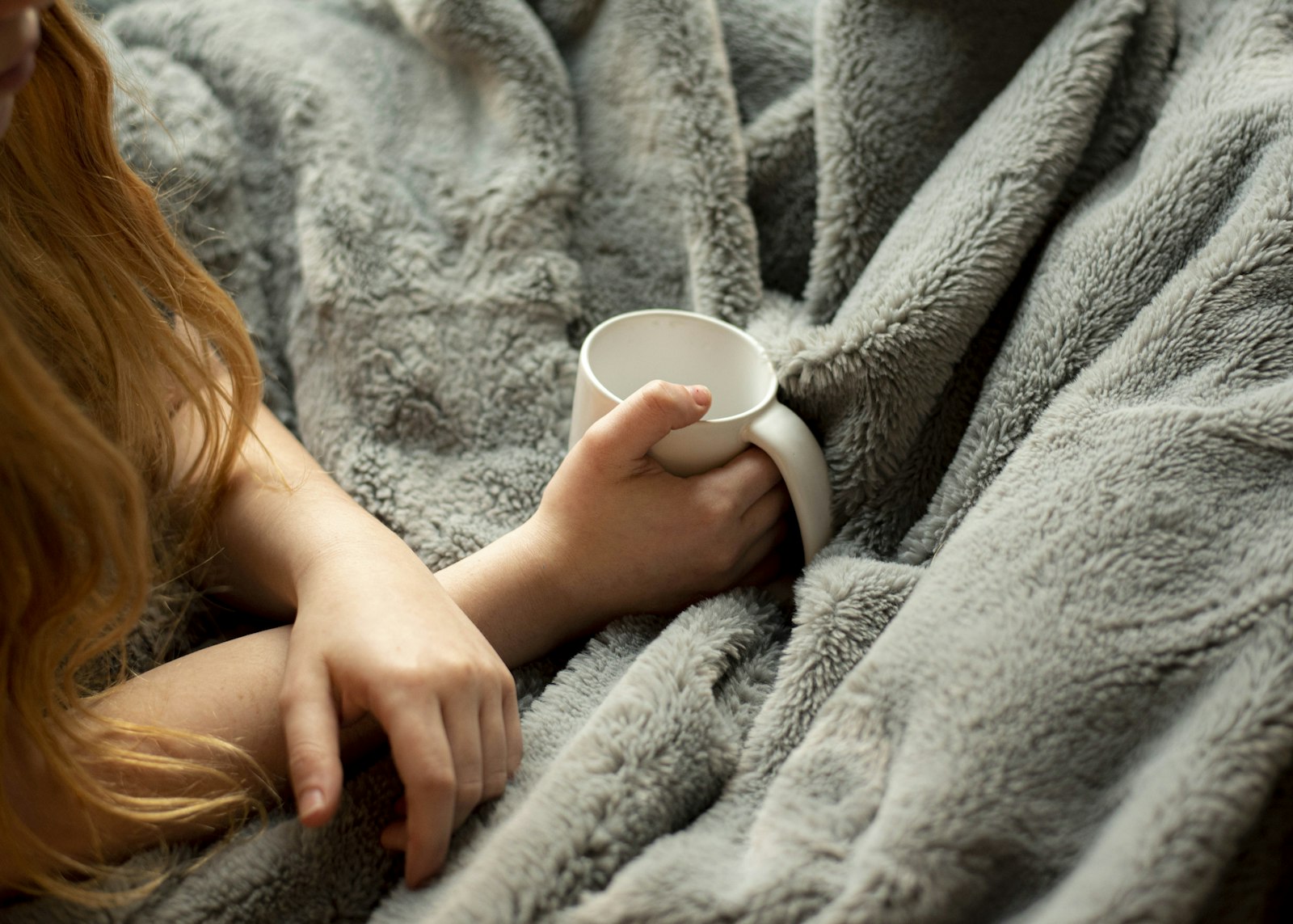Frau hält eine weiße Keramiktasse