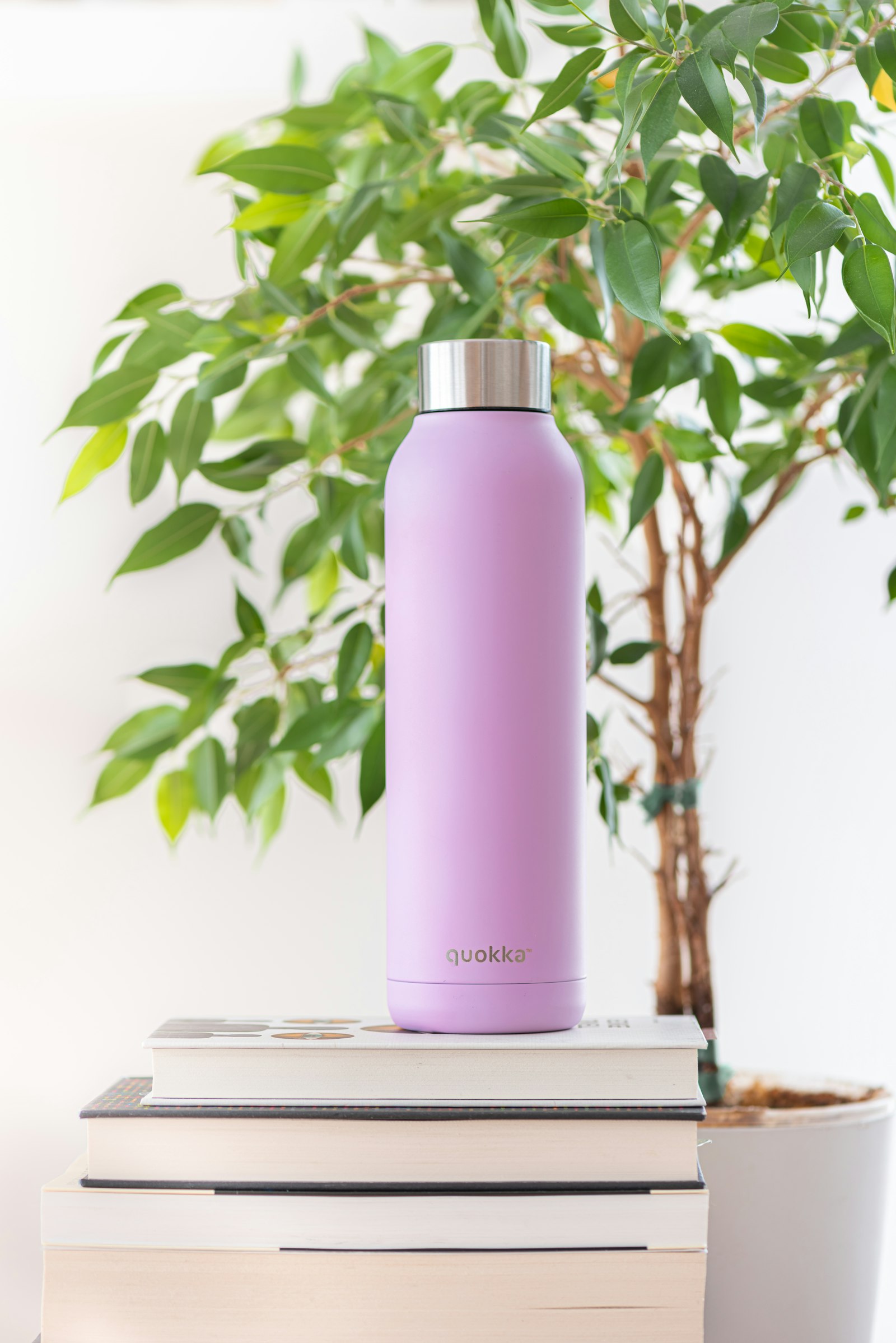 weiße und rosa Flasche auf einem weißen Buch