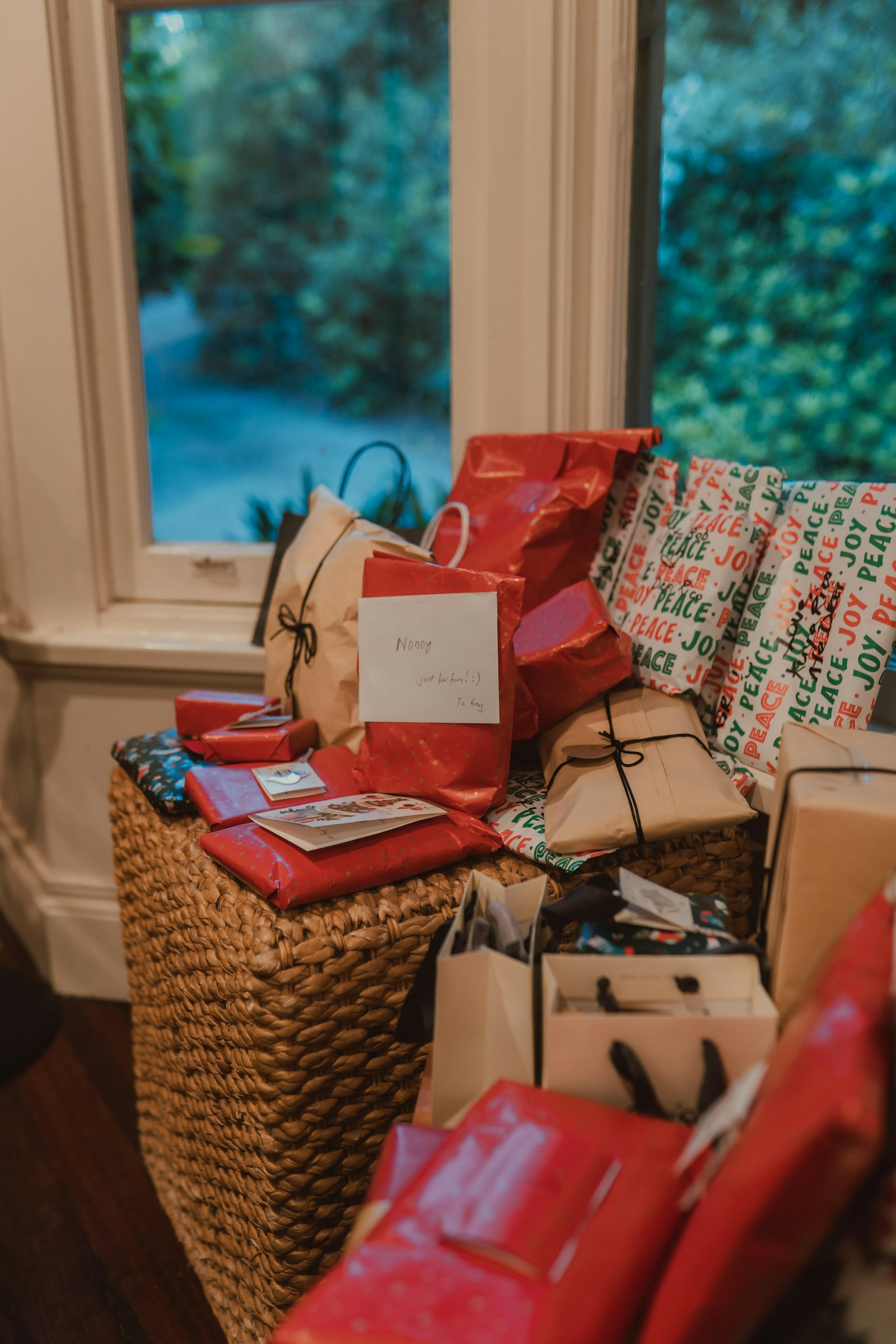 Stapel eingepackter Geschenke in der Nähe eines Fensters